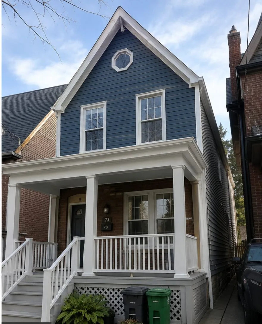 Victorian semi-detached exterior in Cabbagetown, Toronto — siding painted in Benjamin Moore Hale Navy with restored white heritage trim